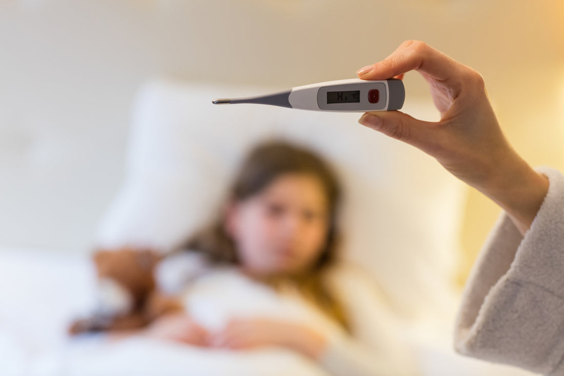 Mor holder termometer foran sin datter